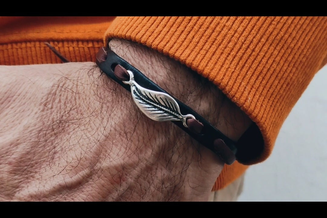 pulsera de cuero y hoja en baño de plata en mano de hombre. Arenas jewelry.